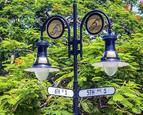 historical street sign in Naples, Florida under blue sky