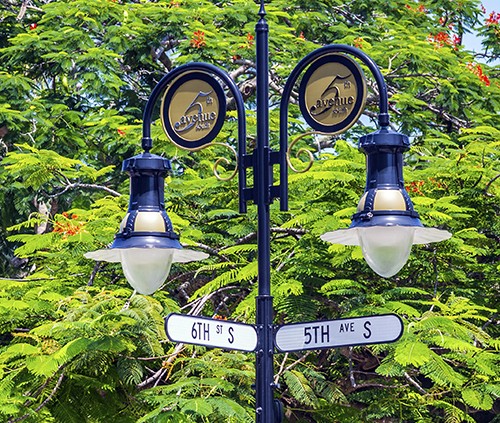 historical street sign in Naples, Florida under blue sky